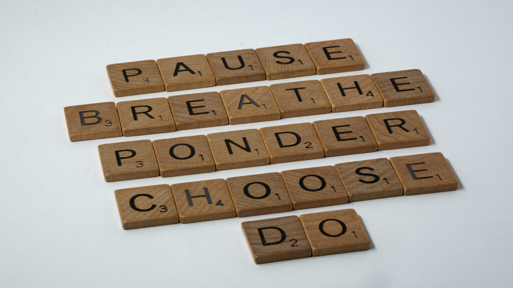 Wooden letter tiles spelling “pause, breathe, ponder, choose, do” on a white background.